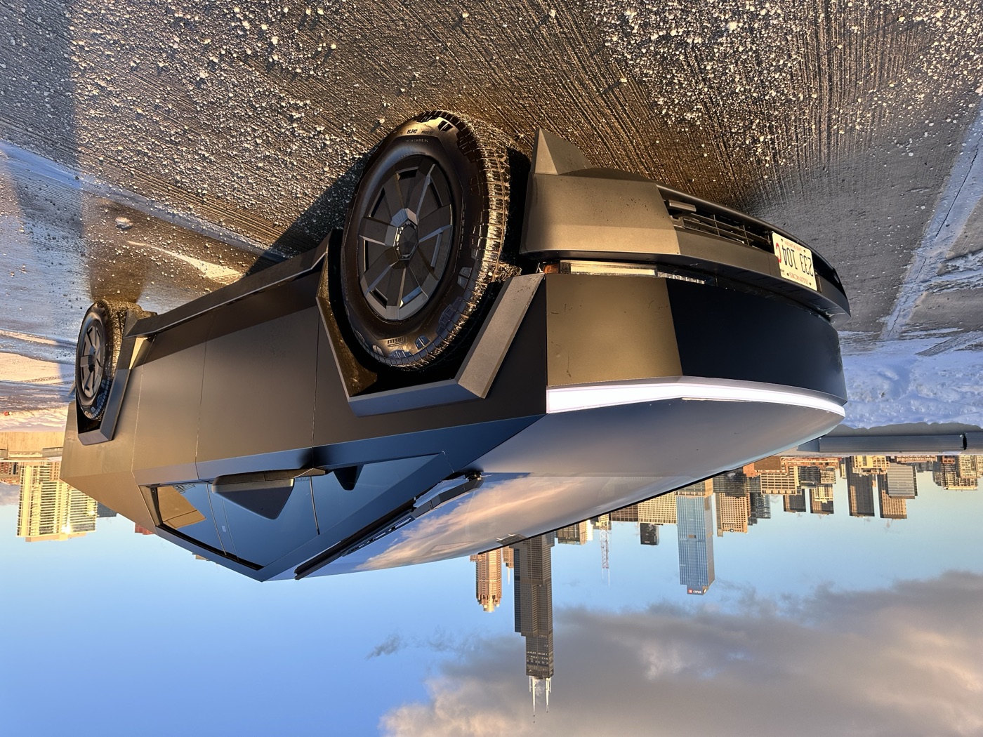 Matte black Tesla Cyberbeast rear quarter view with Chicago skyline